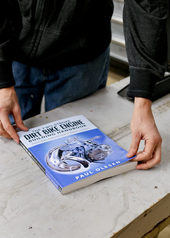 Author, Paul Olesen shows us how thick The Two Stroke Dirt Bike Engine Handbook is